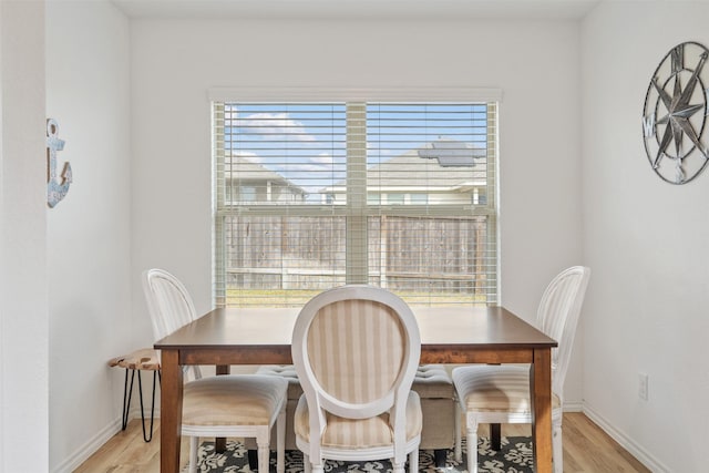 dining room with light wood-type flooring and a wealth of natural light