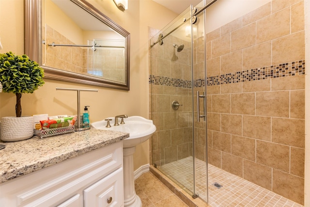 bathroom featuring tile patterned flooring, an enclosed shower, and sink