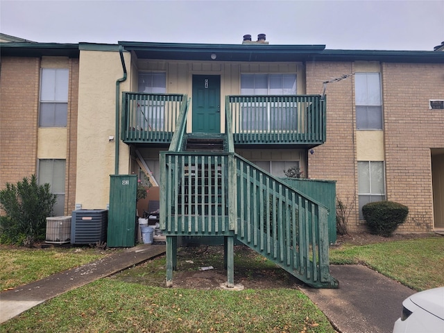 view of building exterior with stairs and central AC