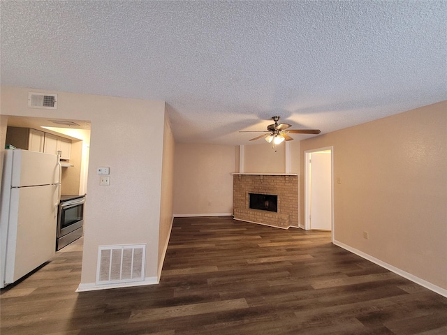 unfurnished living room with dark hardwood / wood-style flooring, a brick fireplace, a textured ceiling, and ceiling fan