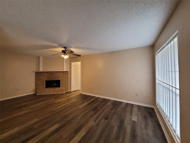 unfurnished living room with a fireplace, a textured ceiling, ceiling fan, and dark hardwood / wood-style floors