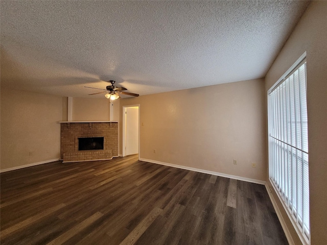 unfurnished living room with baseboards, a fireplace, ceiling fan, and dark wood-style flooring