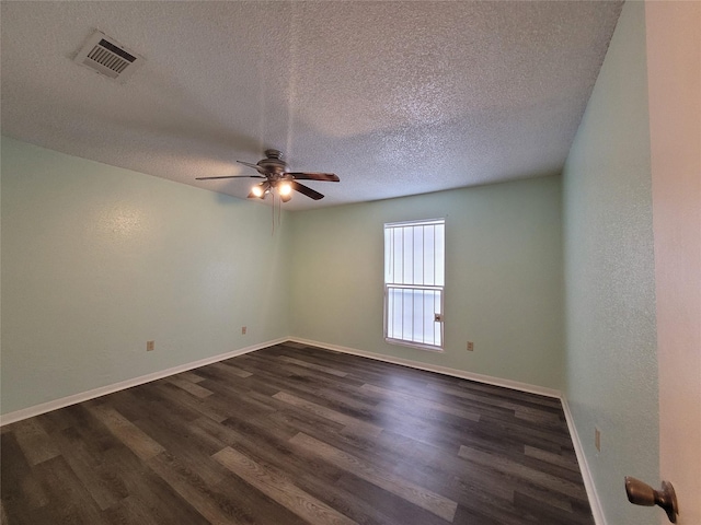 spare room featuring visible vents, baseboards, a textured ceiling, a ceiling fan, and dark wood-style flooring