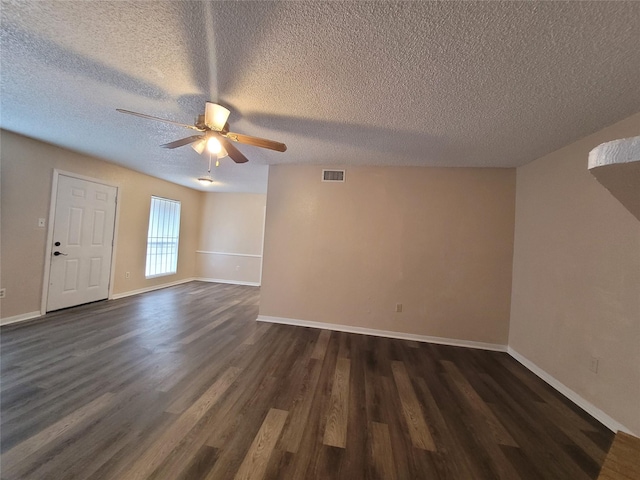 interior space with dark wood-style floors, visible vents, baseboards, and a ceiling fan