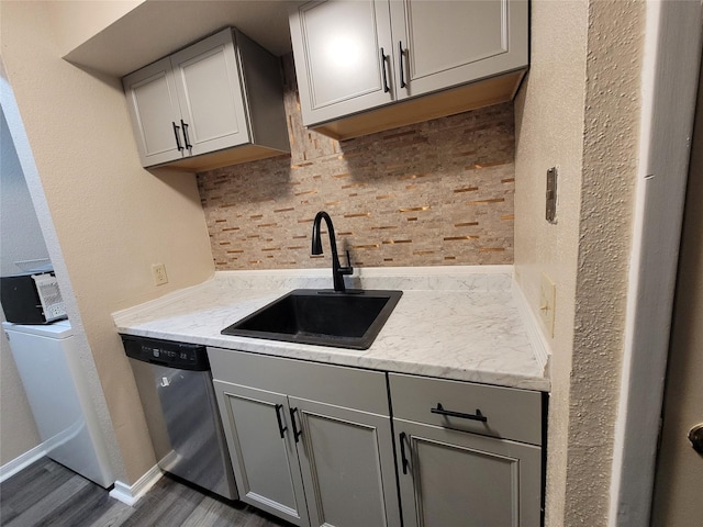 kitchen featuring gray cabinetry, stainless steel dishwasher, and a sink