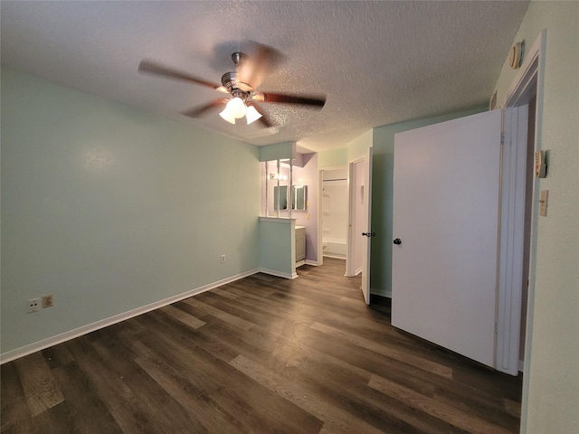 unfurnished bedroom featuring dark wood-type flooring, a ceiling fan, a textured ceiling, ensuite bath, and baseboards