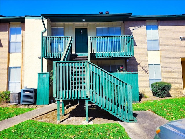 view of building exterior with stairway and central air condition unit