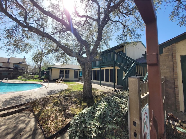 exterior space featuring stairs, a patio, a fenced in pool, and fence