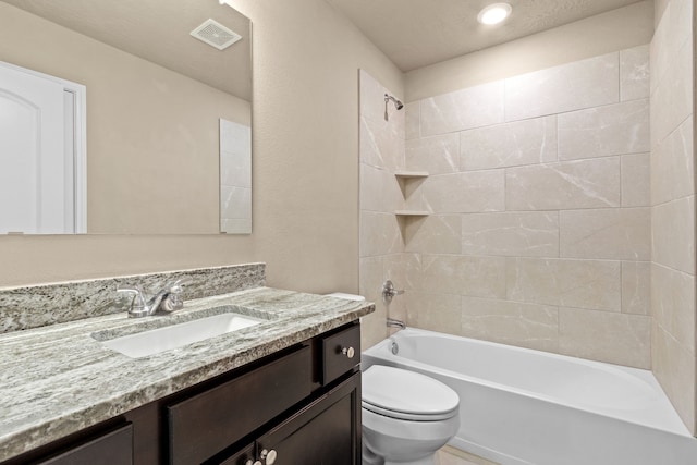 full bathroom with toilet, tiled shower / bath combo, and vanity