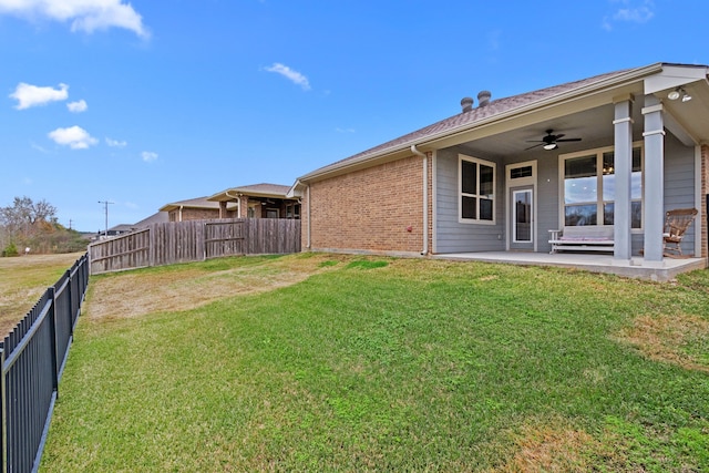 view of yard with ceiling fan and a patio