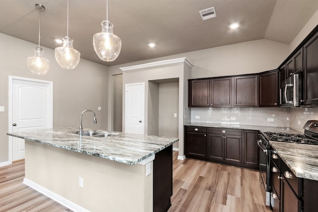 kitchen with sink, decorative backsplash, a kitchen island with sink, and range with gas cooktop