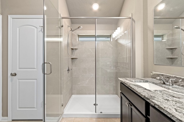 bathroom featuring vanity, tile patterned flooring, and a shower with shower door