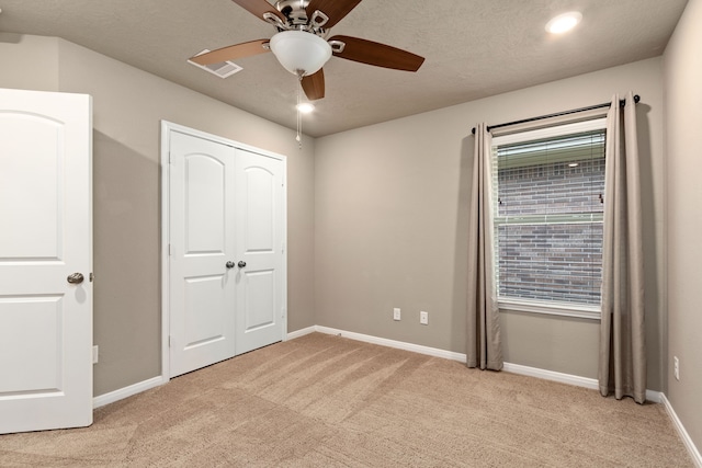 unfurnished bedroom with ceiling fan, a closet, and light carpet