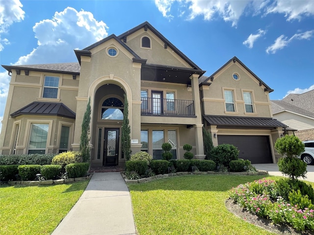 view of front of home with a garage, a front yard, and a balcony