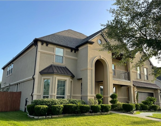 view of front of home with a balcony, a garage, and a front yard