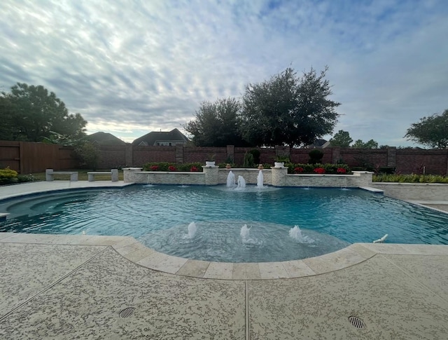 view of swimming pool with pool water feature and a patio area