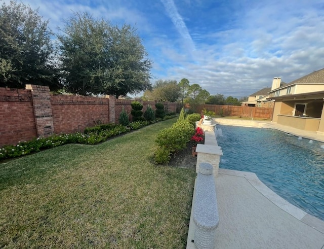 view of swimming pool with a yard