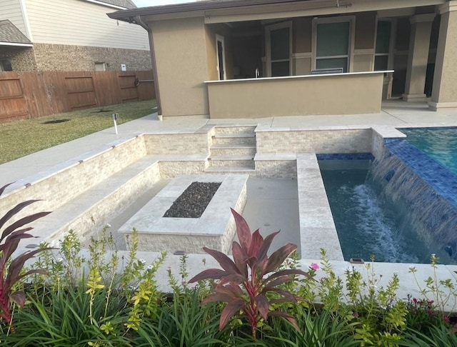 exterior space with a fire pit, a patio area, and pool water feature