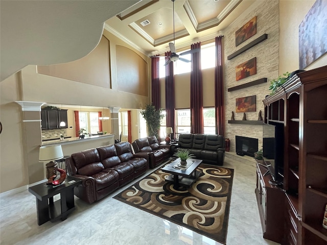 living room featuring a towering ceiling, a healthy amount of sunlight, coffered ceiling, and a stone fireplace