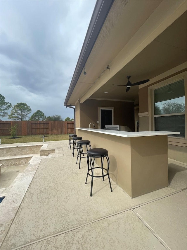 view of patio with a bar and ceiling fan