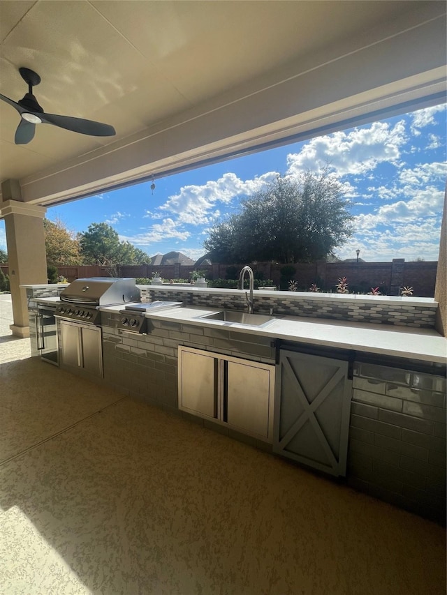 view of patio / terrace featuring exterior kitchen, ceiling fan, sink, and grilling area