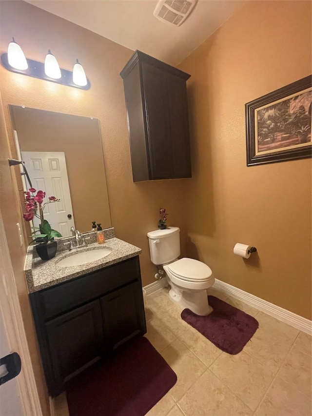 bathroom with tile patterned flooring, vanity, and toilet