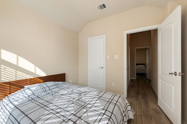 bedroom featuring lofted ceiling and dark hardwood / wood-style floors