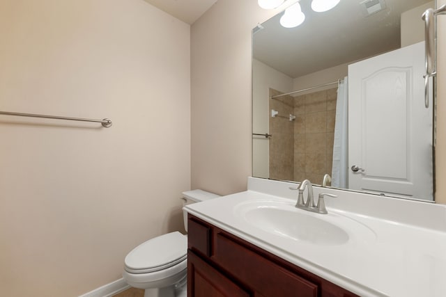 bathroom with curtained shower, vanity, and toilet