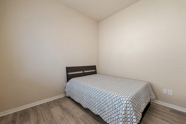 bedroom featuring lofted ceiling and light hardwood / wood-style floors