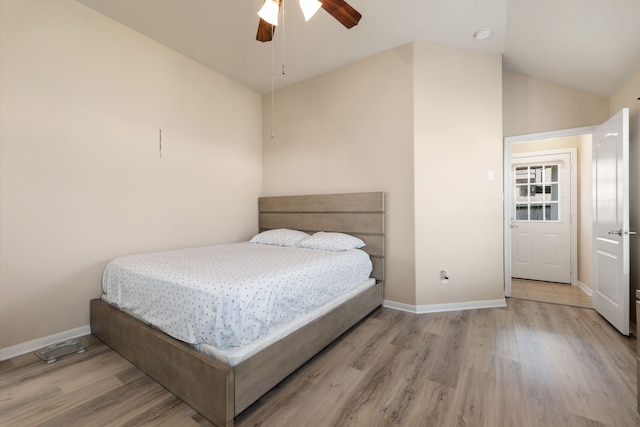 bedroom with ceiling fan, vaulted ceiling, and light hardwood / wood-style flooring