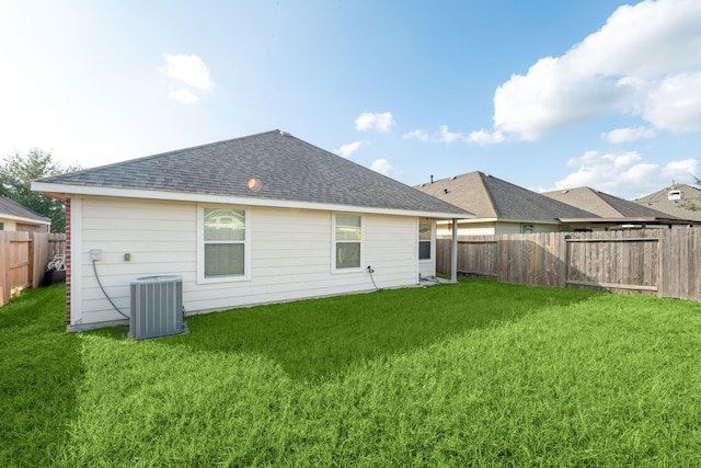 rear view of property featuring a lawn and central AC