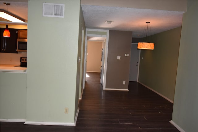 hall featuring a textured ceiling and dark hardwood / wood-style floors