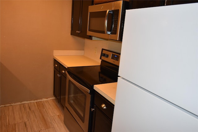 kitchen with light hardwood / wood-style flooring and appliances with stainless steel finishes