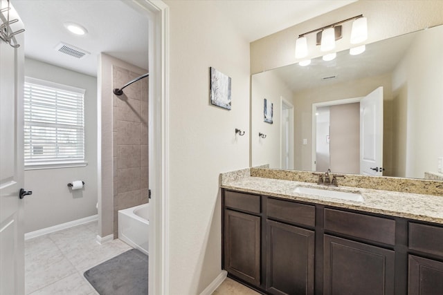 bathroom featuring vanity, tile patterned floors, and tiled shower / bath combo