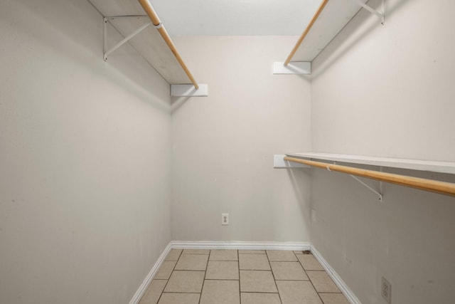 walk in closet with light tile patterned floors