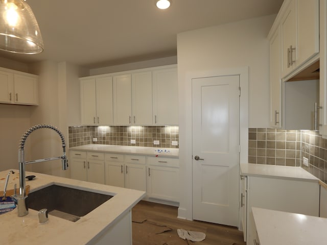 kitchen featuring a sink, recessed lighting, dark wood-style flooring, white cabinetry, and decorative backsplash