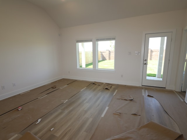 interior space featuring vaulted ceiling, wood finished floors, and a healthy amount of sunlight