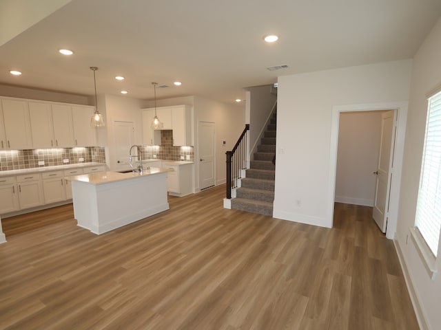21734 Persian Lake Dr, Cypress, TX 77433 - kitchen featuring a sink, tasteful backsplash, recessed lighting, light wood finished floors, and light countertops