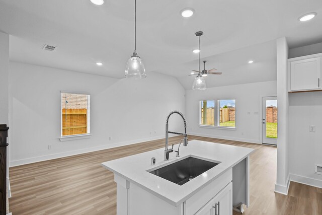 21734 Persian Lake Dr, Cypress, TX 77433 - kitchen featuring open floor plan, a sink, light countertops, light wood-style floors, and vaulted ceiling