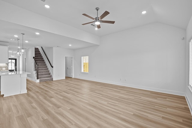 21734 Persian Lake Dr, Cypress, TX 77433 - unfurnished living room featuring stairs, plenty of natural light, recessed lighting, a ceiling fan, and light wood finished floors
