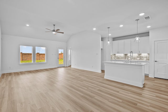 21734 Persian Lake Dr, Cypress, TX 77433 - unfurnished living room featuring a sink, a ceiling fan, light wood-type flooring, vaulted ceiling, and baseboards