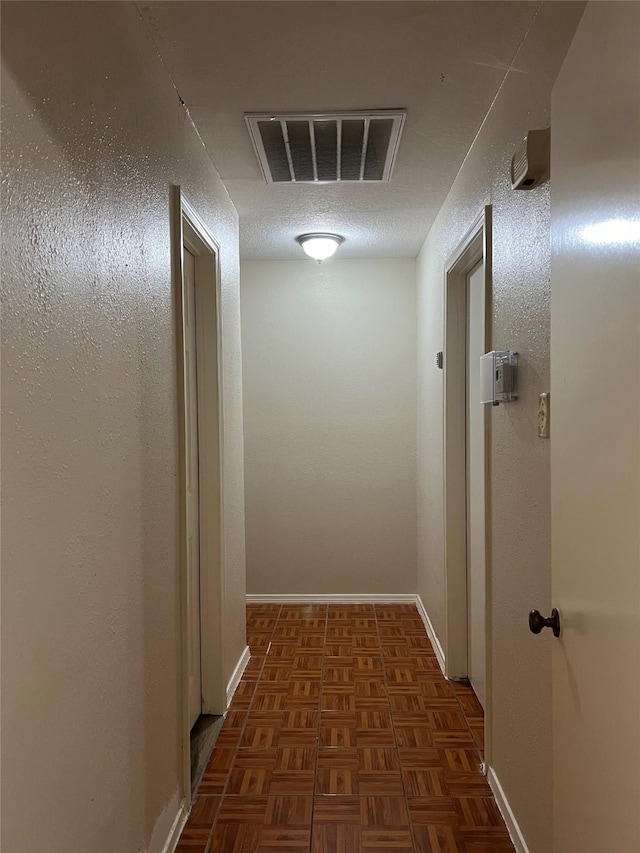 corridor featuring dark parquet floors and a textured ceiling