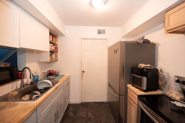 kitchen featuring stainless steel appliances, butcher block countertops, gray cabinetry, and sink