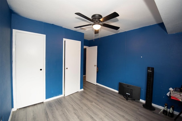 unfurnished bedroom with ceiling fan and hardwood / wood-style flooring