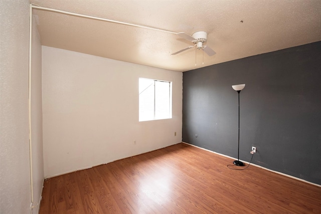 spare room featuring wood-type flooring and ceiling fan