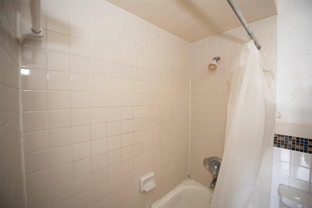 bathroom featuring a textured ceiling and shower / bath combo with shower curtain