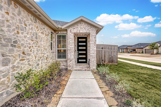 view of exterior entry with a yard