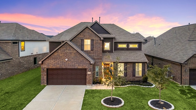 view of front of house with a garage and a yard