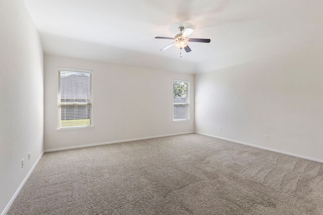 carpeted spare room featuring ceiling fan