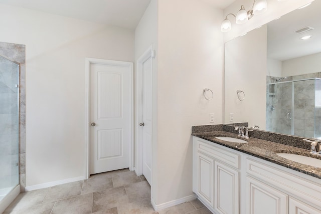 bathroom featuring a shower with shower door, vanity, and tile patterned floors